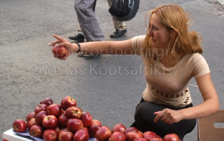 Μετανάστρια πουλάει μήλα στο κέντρο της Αθήνας.